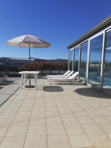 a patio with a table and an umbrella on a building at GOLD HOUSE in Maranello