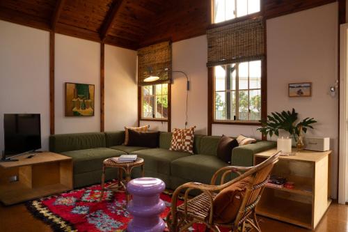 a living room with a green couch and a tv at Porpoise Palace, The South Coast Sandcastles in Huskisson in Huskisson