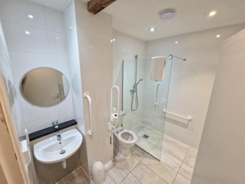 a bathroom with a toilet and a glass shower at Barley End in Leighton Buzzard