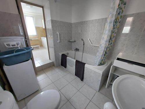 un bagno con un water, una vasca e un lavandino di La Petite Maison à la Campagne a Guer