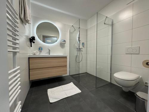 een badkamer met een douche, een toilet en een wastafel bij Havellandhalle Resort in Seeburg