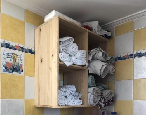 a wooden cabinet filled with towels in a bathroom at Villa Evenik in Eretria