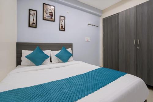 a bedroom with a large bed with blue pillows at The Balcony Suites in Hyderabad