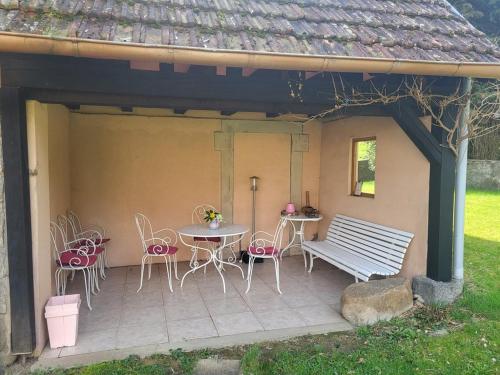 a patio with a table and chairs and a bench at Le GITE Du MEIERHOF in Muhlbach-sur-Munster