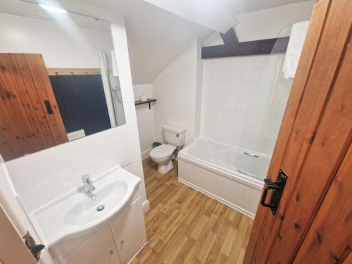 a bathroom with a white sink and a toilet at The Granary in Leighton Buzzard