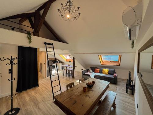 ein Wohnzimmer mit einem Tisch und einem Sofa in der Unterkunft Cocon sous les toits in Albertville