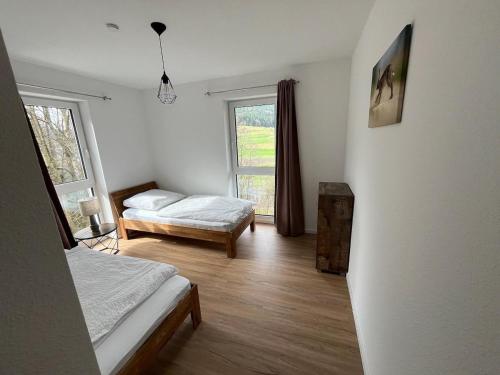 1 dormitorio con 2 camas y ventana en Ferienwohnungen Greve, en Baiersbronn