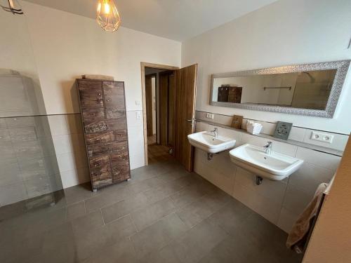 La salle de bains est pourvue de 2 lavabos et d'un miroir. dans l'établissement Ferienwohnungen Greve, à Baiersbronn