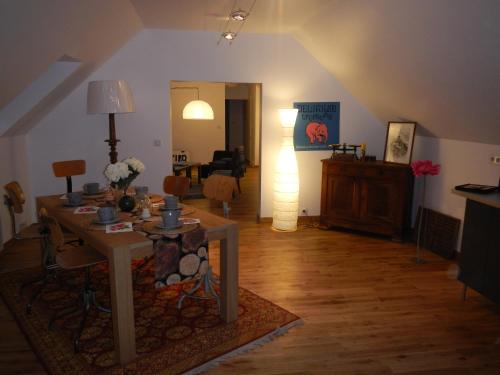 sala de estar con mesa y lámpara en L'appartement du Manoir, en Gauciel