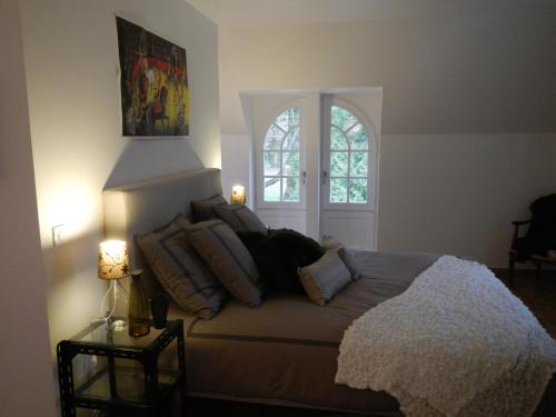 una camera da letto con letto, cuscini e finestra di L'appartement du Manoir a Gauciel