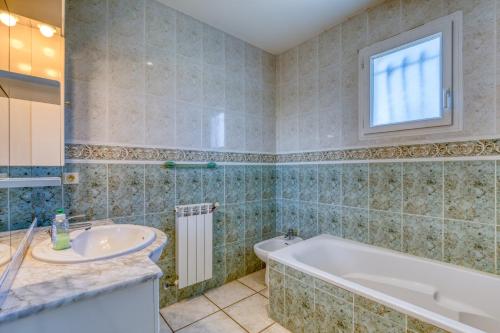 uma casa de banho com uma banheira e um lavatório em Villa F5 Jardin, Piscine em Saint-Gély-du-Fesc