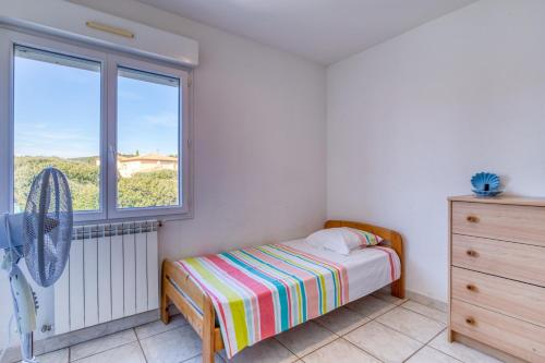 um pequeno quarto com uma cama e uma janela em Villa F5 Jardin, Piscine em Saint-Gély-du-Fesc