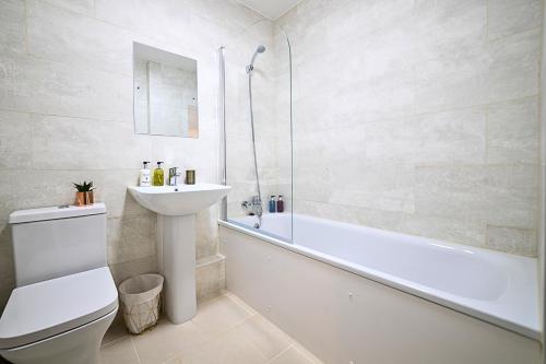 uma casa de banho com um WC, um lavatório e uma banheira em Heathrow RARE find 2 Bedroom plus 2 Bathroom flat - Sleeps 6- Free Parking- Close to Heathrow Terminals-Quiet development em Stanwell