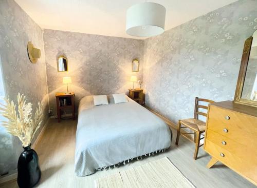 - une chambre avec un lit, deux tables et une chaise dans l'établissement l'amour, le rire et la famille, à Hillion