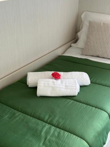 two towels on a bed with a red rose on it at A due passi dal lago - Cernobbio con Terrazza in Cernobbio