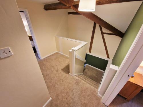 an attic room with a staircase with a stair case at The Mill in Leighton Buzzard