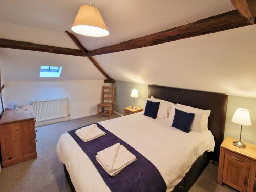 a bedroom with a large bed with blue pillows at The Mill in Leighton Buzzard