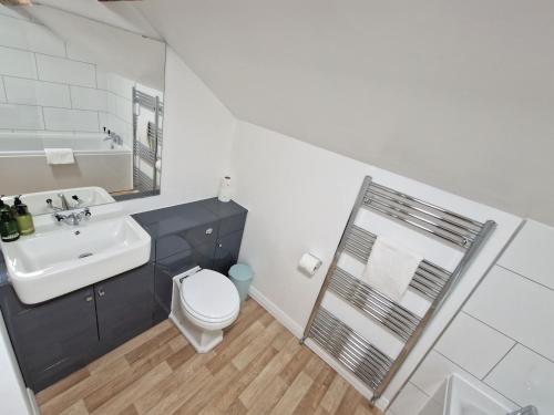 a white bathroom with a sink and a toilet at The Mill in Leighton Buzzard