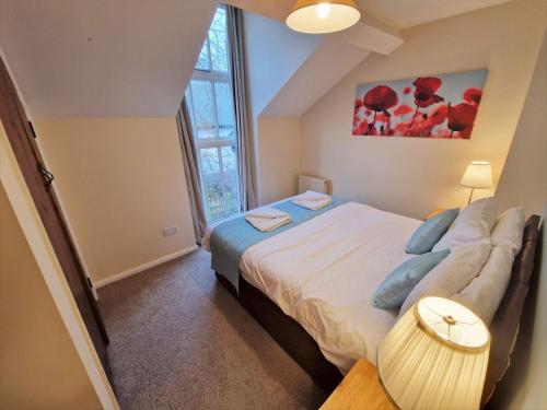 a bedroom with a bed and a large window at The Dairy in Leighton Buzzard