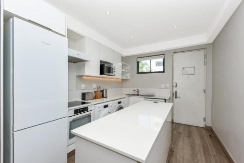 a kitchen with white appliances and a white counter top at The Regency Apartments in Pretoria