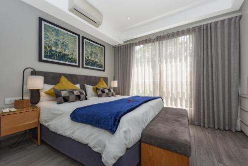 a bedroom with a large bed and a window at The Regency Apartments in Pretoria
