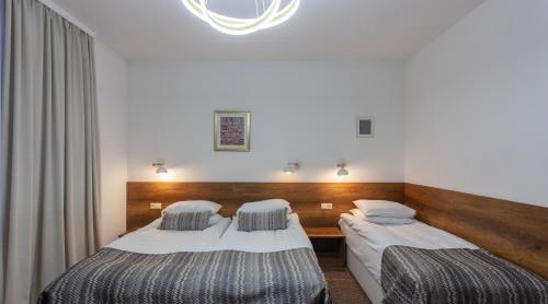 a hotel room with two beds and a chandelier at Alliance Hotel in Tbilisi City