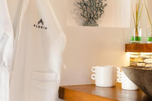 a towel on a table next to a sink and a cup at Aldeia Jericoacoara - Suites Privativas in Jericoacoara