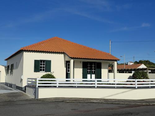 a house with a white fence in front of it at Casa da Villa in Madalena