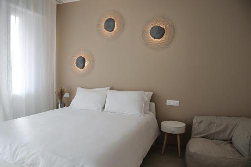 a bedroom with a white bed and a couch at Casa Febo, in centro con parcheggio privato a 200 mt dal mare in Bordighera