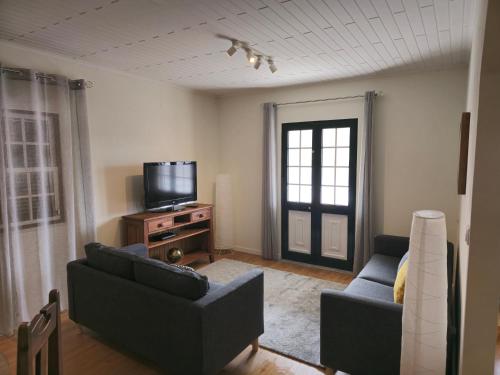 a living room with two couches and a television at Casa da Villa in Madalena