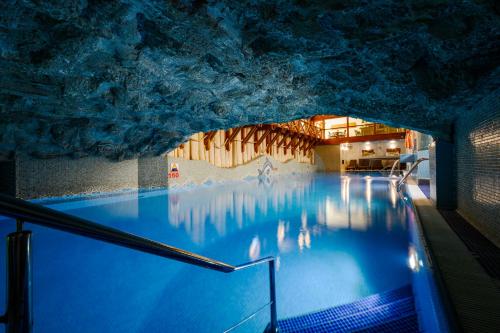 Hotel Belvedere Resort&SPA في زاكوباني: مسبح في كهف به ماء ازرق