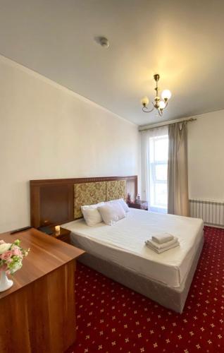 una camera con un grande letto e un tappeto rosso di Гостиничный комплекс Белес a Zaozërnyy