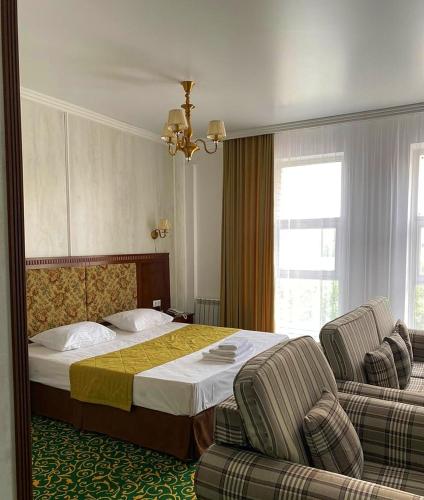 ZaozërnyyにあるГостиничный комплекс Белесのベッド1台と椅子2脚が備わるホテルルームです。