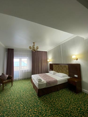 1 dormitorio con 1 cama, 1 silla y 1 ventana en Гостиничный комплекс Белес en Zaozërnyy