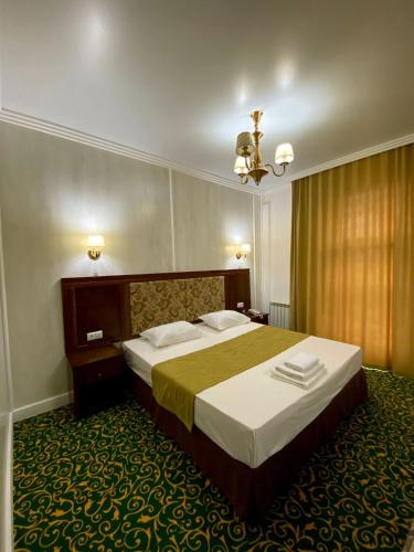 Habitación de hotel con cama y lámpara de araña. en Гостиничный комплекс Белес en Zaozërnyy