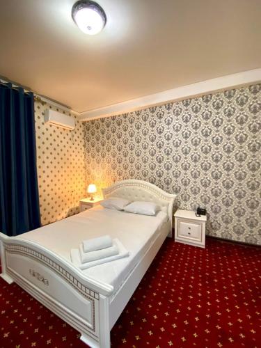 1 dormitorio con cama blanca y alfombra roja en Гостиничный комплекс Белес, en Zaozërnyy