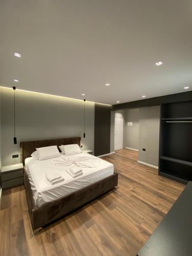 1 dormitorio con 1 cama grande con sábanas blancas en Hotel Erioni, en Sarandë