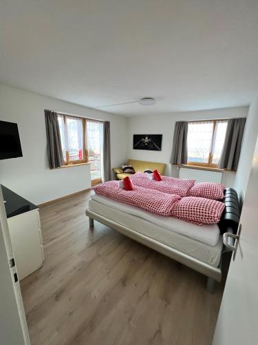 a bedroom with a large bed with red pillows at Haus Augstbord BNB Zimmer in Unterbäch