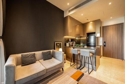 uma sala de estar com um sofá e uma cozinha em MarQ Luxury Apartment 48 Gym, City Center, Infinity Pool, Netflix em Ho Chi Minh