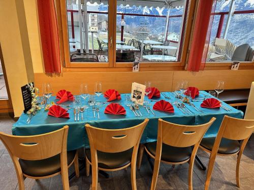 a blue table with red napkins and glasses on it at Haus Augstbord BNB Zimmer in Unterbäch