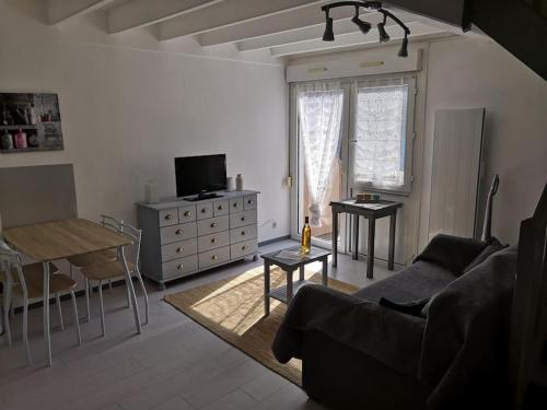 a living room with a couch and a table at Appartement proche de la plage des minimes in La Rochelle