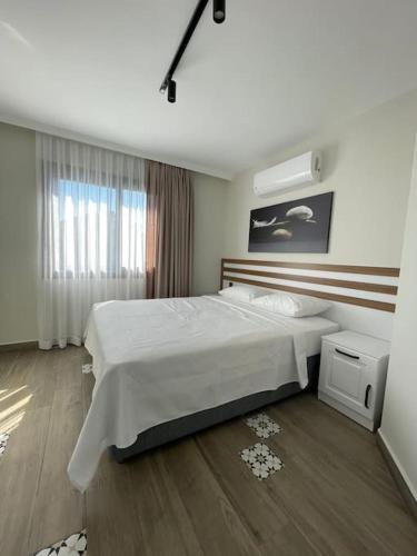 ein Schlafzimmer mit einem großen Bett und einem Fenster in der Unterkunft Zehra Suites Boutique Apartment#6, 300 meters from the sea in Marmaris