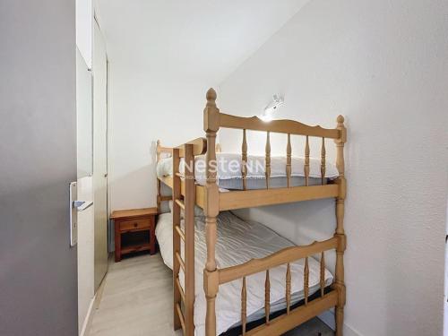 Ce lit superposé en bois se trouve dans un dortoir doté d'une porte. dans l'établissement 3206-T2 première ligne vue mer, à Argelès-sur-Mer