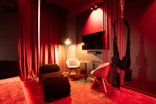 a living room with red curtains and a table and chairs at Évasion intime : Love Room de luxe à Cannes in Cannes