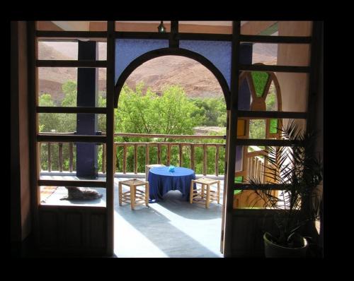 una puerta abierta a un patio con una mesa azul en Guest house Amande, en Tinerhir