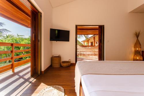 a bedroom with a bed and a balcony at Aldeia Jericoacoara - Suites Privativas in Jericoacoara