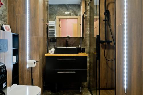 a bathroom with a sink and a mirror at Apartament Orlando w Porto Łeba 350m od morza in Łeba