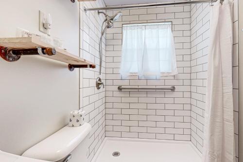 uma casa de banho em azulejos brancos com uma banheira e um WC. em Cribb's Cove em Whittier