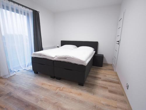 a bedroom with a bed and a large window at VacationClub - Siedem Wysp Apartament 31 in Sianozety
