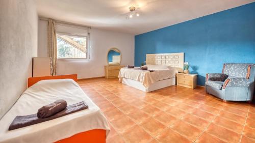 um quarto com 2 camas e uma parede azul em Costacabana - Villa Marysol em Lloret de Mar